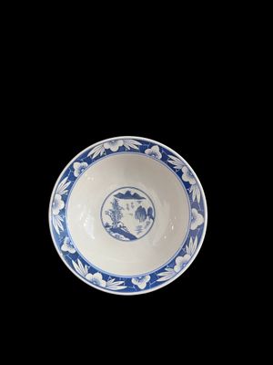 bol en porcelaine bleue et blanche orné d'un oiseau sur le rebord