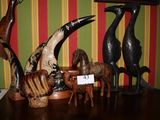 une sculpture en bois représentant un oiseau, une girafe, un cheval et une girafe, posée sur une table