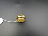 a close up of a ring with a tag on a table