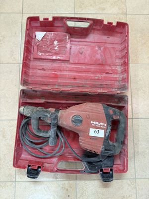 une boîte à outils rouge contenant un marteau électrique