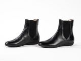 a pair of black leather chelsea boots on a white background
