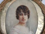 portrait of a woman in a white dress in a gold frame
