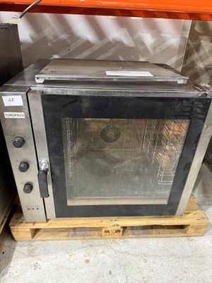 a silver microwave sitting on a pallet in a warehouse