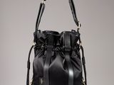 sac seau en cuir noir orné de pompons suspendus à la poignée