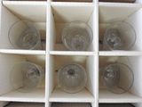 six empty wine glasses in a white box
