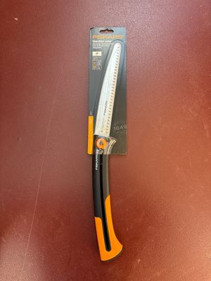 un gros plan d'un couteau posé sur une surface marron, avec un manche noir