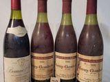 quatre bouteilles de vin sont alignées sur une table