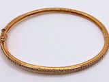 a close up of a gold plated bang bracelet with diamonds