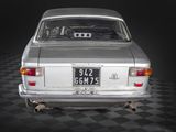a silver car that is sitting on a black and white checkered floor