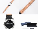 an image of a watch, pen, wallet, and other items laid out on a white surface