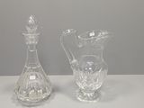 two clear glass vases sitting on top of a white table