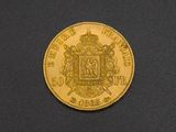 a close up of a gold coin on a black surface