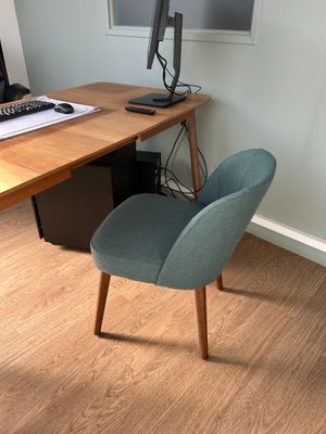 un bureau avec un écran d'ordinateur et une chaise devant