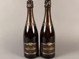 deux bouteilles de vin posées sur une table l'une à côté de l'autre