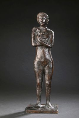 a bronze statue of a woman standing with her arms crossed