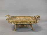 an ornate gold plate with a large fish on it