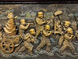 a bronze relief of a group of people on a boat