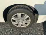 a white car with a flat tire on a gravel road