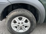un camion vert avec un pneu crevé, garé sur un parking