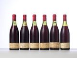 six bottles of wine lined up in a row on a table