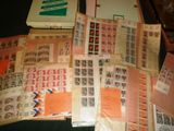 beaucoup de timbres posés sur une table, à côté d'un livre