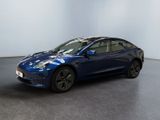 une Tesla Model 3 bleue garée dans une pièce blanche