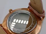 a close up of a wrist watch on a white surface