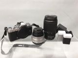 une photo représentant un appareil photo et un objectif posés sur une table