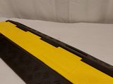 a close up of a yellow and black rubber ramp on a white surface