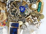 a pile of assorted jewelry on a white surface