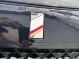 a close up of a person ' s hand on the front of a car