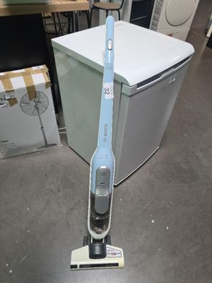 un aspirateur posé par terre devant un réfrigérateur