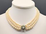a close up of a necklace with pearls on a mannequin