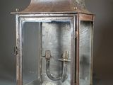 an old fashioned metal lantern with a glass door and a metal handle