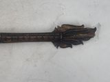 an old metal arrow with a wooden handle on a white surface