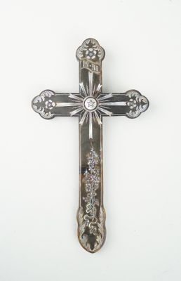 une croix argentée sur une surface blanche, sur fond blanc