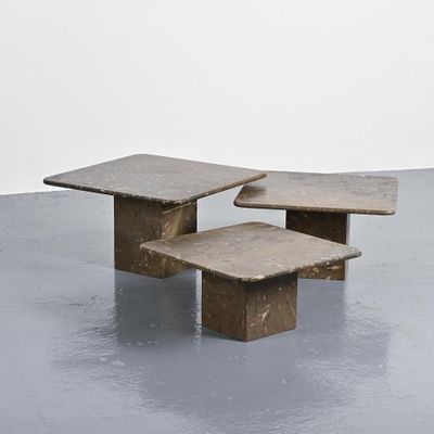 three stone tables sit on top of a cement floor
