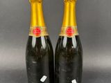 two bottles of champagne sitting next to each other on a table