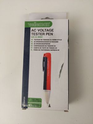 packaging of a red and black pen sitting on top of a white table