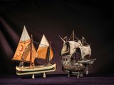 two model ships on display on a purple surface
