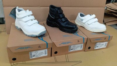 trois paires de chaussures posées sur une boîte en carton