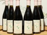six bouteilles de vin sont alignées sur un plateau en bois