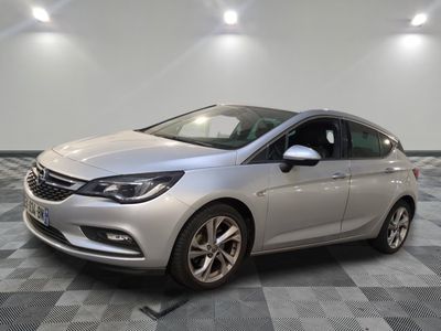 une voiture argentée garée dans une pièce au sol en damier