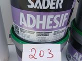 two buckets of adhesive sitting on top of each other on a table