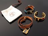 three bracelets and a bag on a table with a drawsack