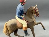figurine of a man riding a horse on a green base