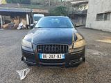 a black car parked in a parking lot with a number plate on the front