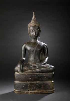 an image of a bronze statue of a person sitting on top of a pile of books
