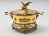 an image of a gold plate with a bird on top of it