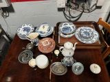 une table en bois sur laquelle se trouve un plateau avec des assiettes et des bols